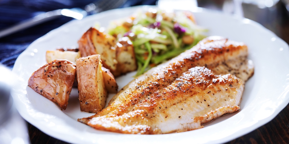 Baked redfish (red drum) with potatoes and greens.