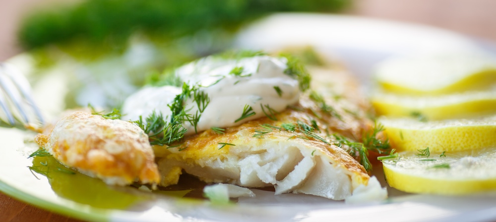 Pan fried redfish recipe for dinner served with lemon slices.