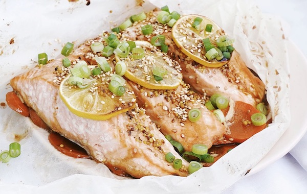 Fish fillets on plate with sauce and sesame seeds.
