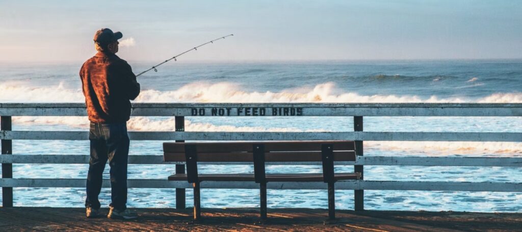 Man pier fishing in the Florida surf.